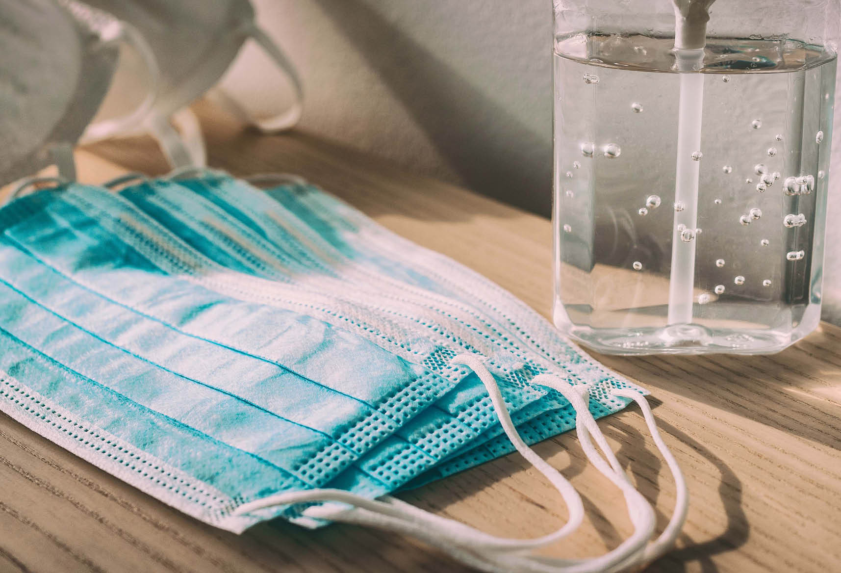 Coronavirus prevention medical surgical masks and hand sanitizer gel bottle dispenser for Covid-19 corona virus protection. Panoramic of PPE.